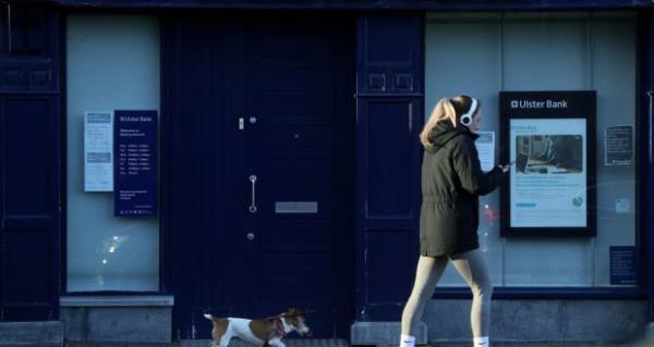 A woman and a dog pass an Ulster Bank branch in Raheny, Dublin. Photograph: Brian Lawless/PA Wire