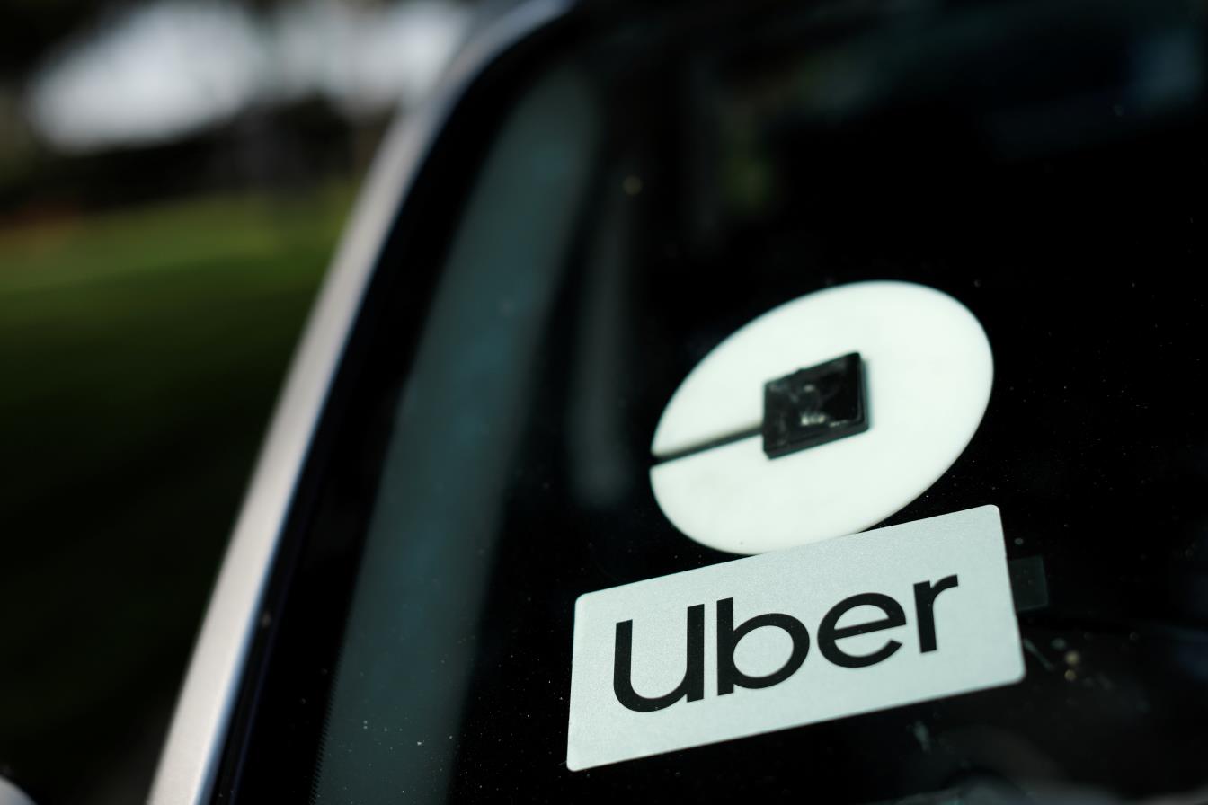 An Uber logo is shown on a rideshare vehicle.,  REUTERS/Mike Blake