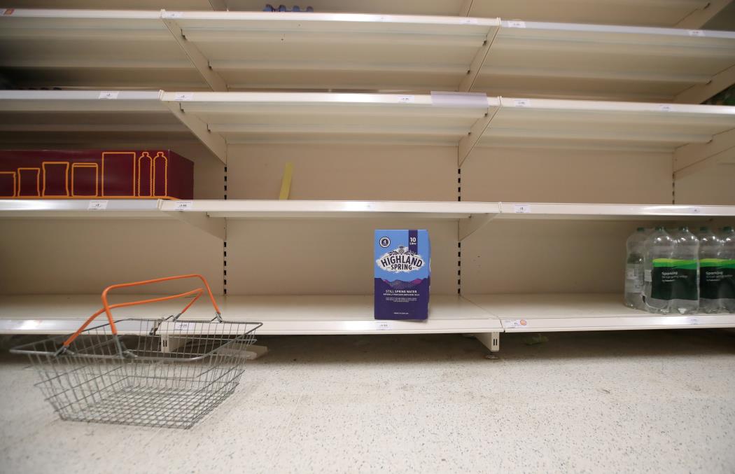 A shopping basket is discarded next to empty shelves of the soft drinks aisle, in Sainsbury's supermarket in Harpenden, Britain, September 22, 2021.  REUTERS/Peter Cziborra     