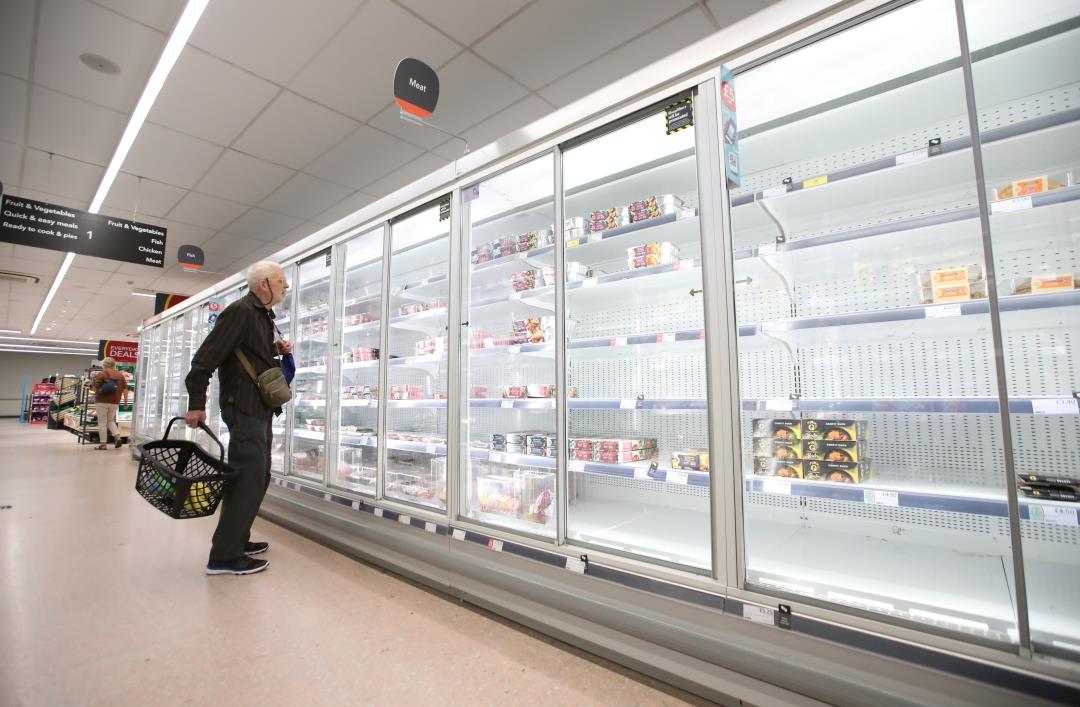 A shopper looks at produce and empty shelves of the meat aisle in Co-Op supermarket, Harpenden, Britain, September 22, 2021.  REUTERS/Peter Cziborra