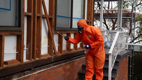Man in PPE detects asbestos in a house